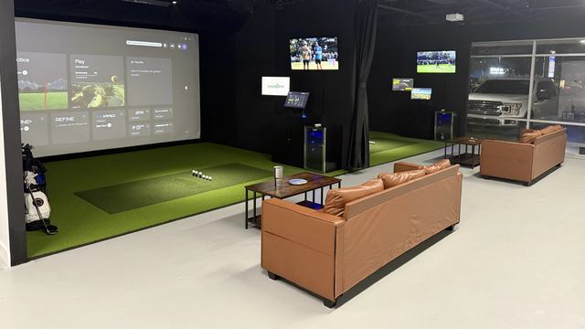 Both simulator bays at FlagShots in Dunedin, Florida, with turf hitting areas, projector screens and leather lounge seating