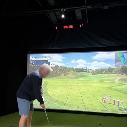 A golfer at address on the turf in a FlagShots bay in Dunedin, FL, lined up to hit into the impact screen