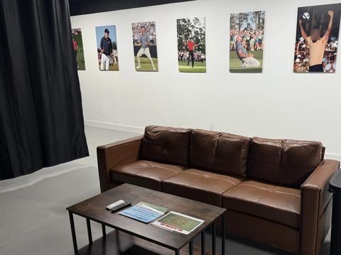 Leather lounge seating facing a simulator bay at FlagShots in Dunedin, Florida